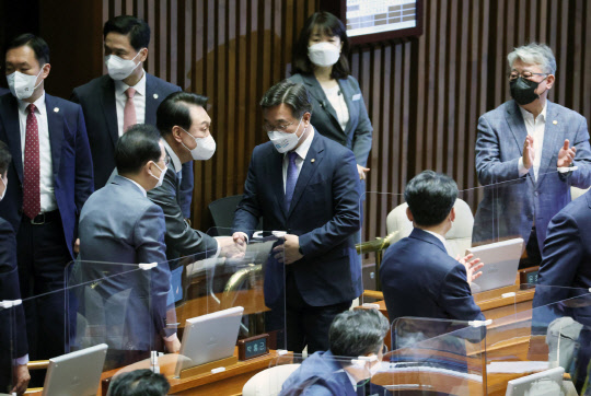 윤석열 대통령이 16일 국회 본회의장에서 열린 추가경정예산안 신속 처리를 위한 시정연설에 입장하며 더불어민주당 윤호중 비상대책위원장과 인사하고 있다. 연합뉴스.